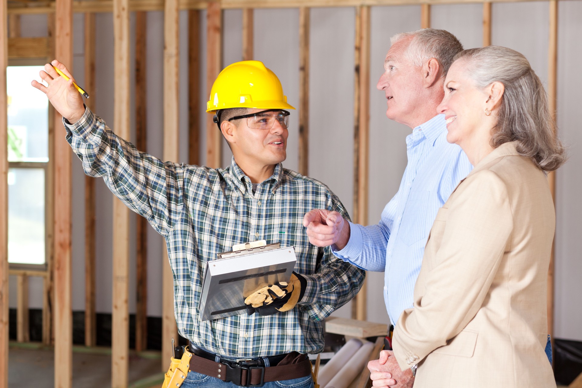 Construction worker discussing house building with home owners